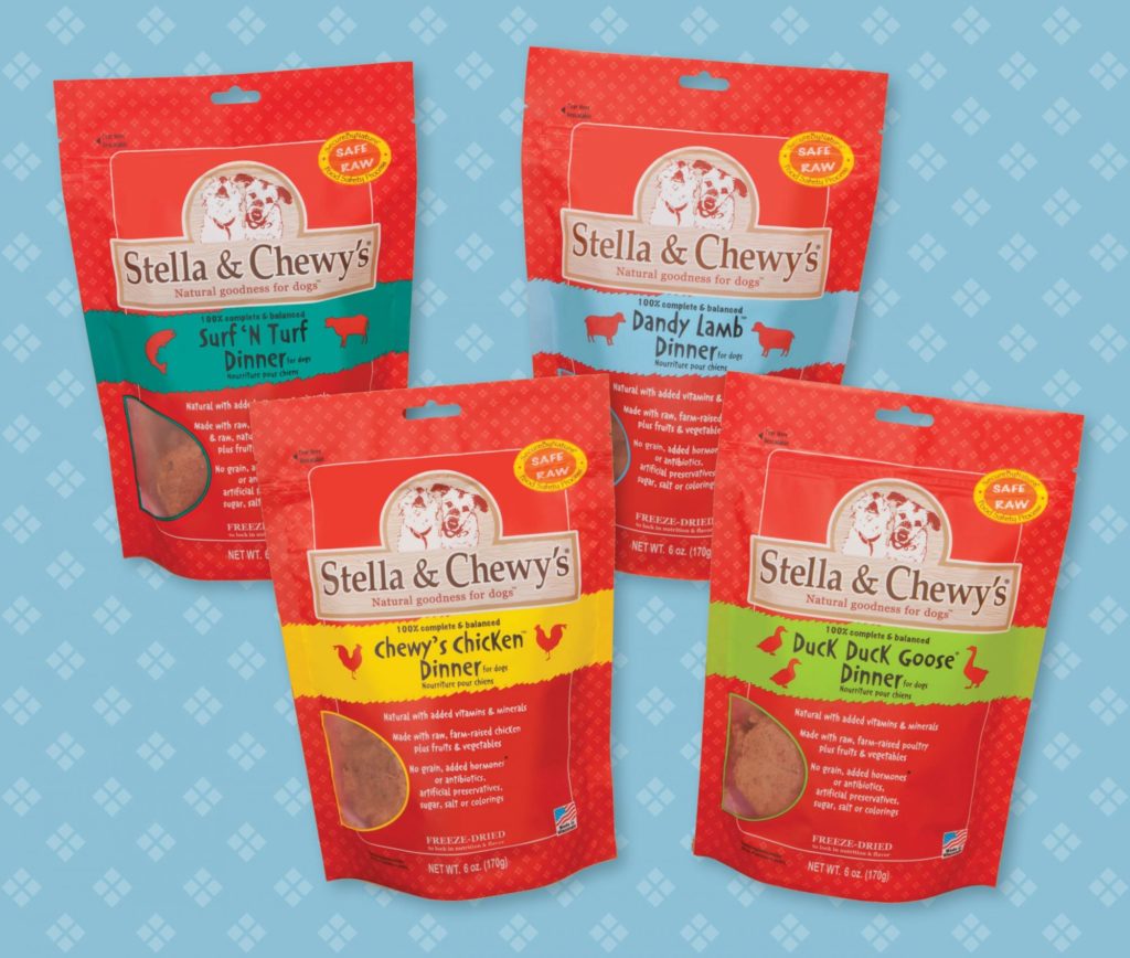 Four packages of Stella & Chewy's raw pet food featuring revitalized and rebranded colors of red packaging with bright contrasting labels. A blue and white background surrounds the packages.